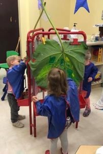 Preschoolers painting leaves to make prints.